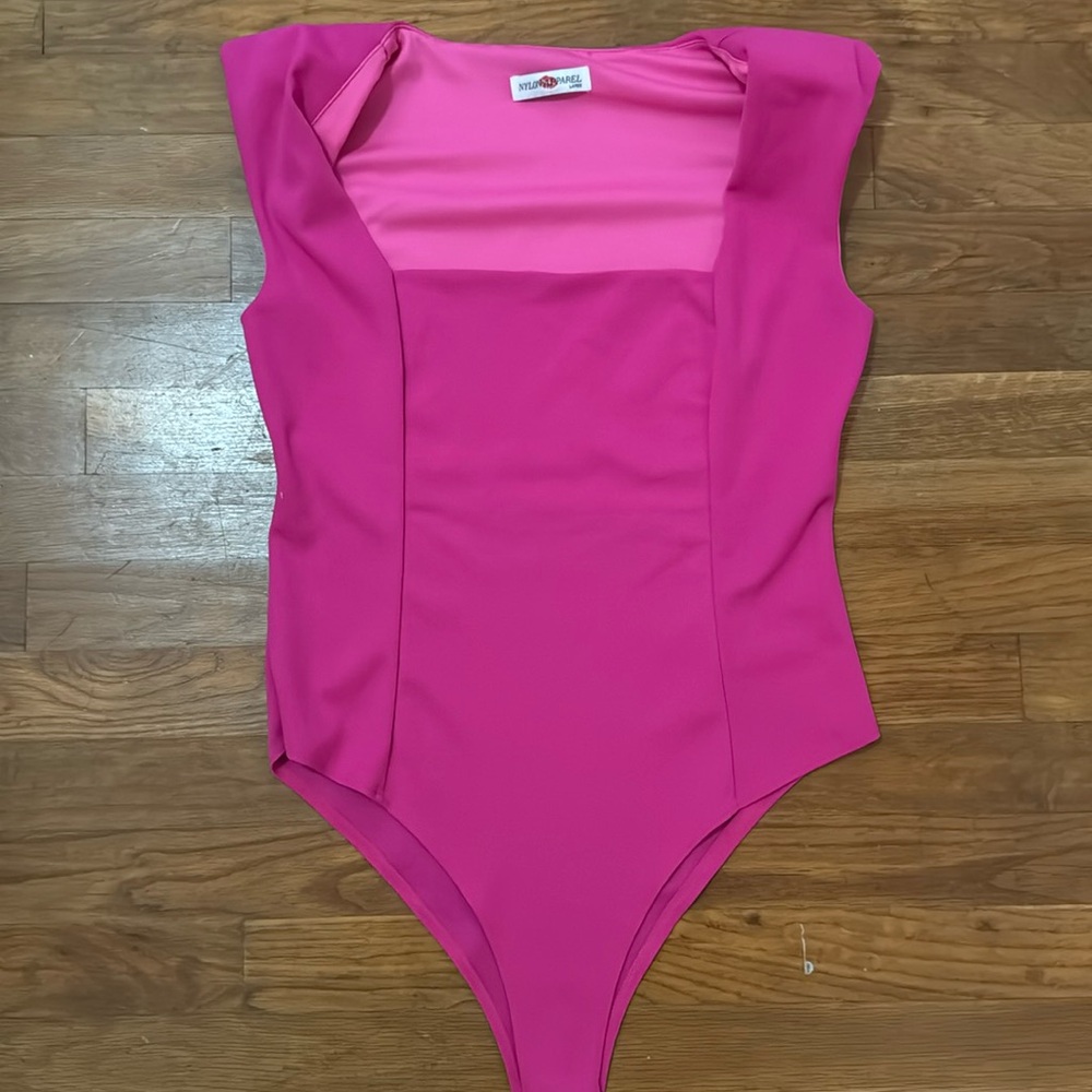 Pink body suit with shoulder pads.